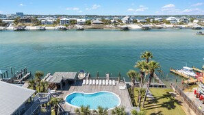 A pool area with a wooden deck, lounge chairs, and a clear blue pool. - Skip the packed high-rises!•
Steps to Beach • Family Ready • 
Gulf View 2BR-2BA (Orange Beach)