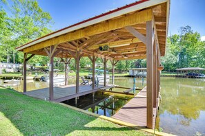 Enjoy serene moments by the lake at this peaceful pavilion, featuring a flat roof and wooden beams.