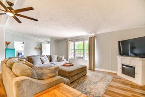 Relax in this spacious living room with a large sectional sofa, flat-screen TV, and wooden coffee table.