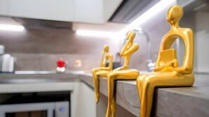A kitchen with a microwave, a red object on the counter, and three golden figures. - Elegantis.it Eat Pray and Love in Rome - Near Navona Square and Campo de' Fiori (Roma)