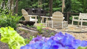A garden with a wooden pergola, Adirondack chairs, and a stone fire pit. -  Welcome to mountain retreat in the tranquil beauty of Rabun County! (Clayton)