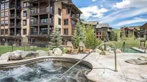 A multi-story hotel with outdoor hot tub and lounge chairs. - Aprés La Joy! AC, Amazing Indoor/Outdoor Kitchen & Deck Space, Private Hot Tub, Amenities! (Steamboat Springs)