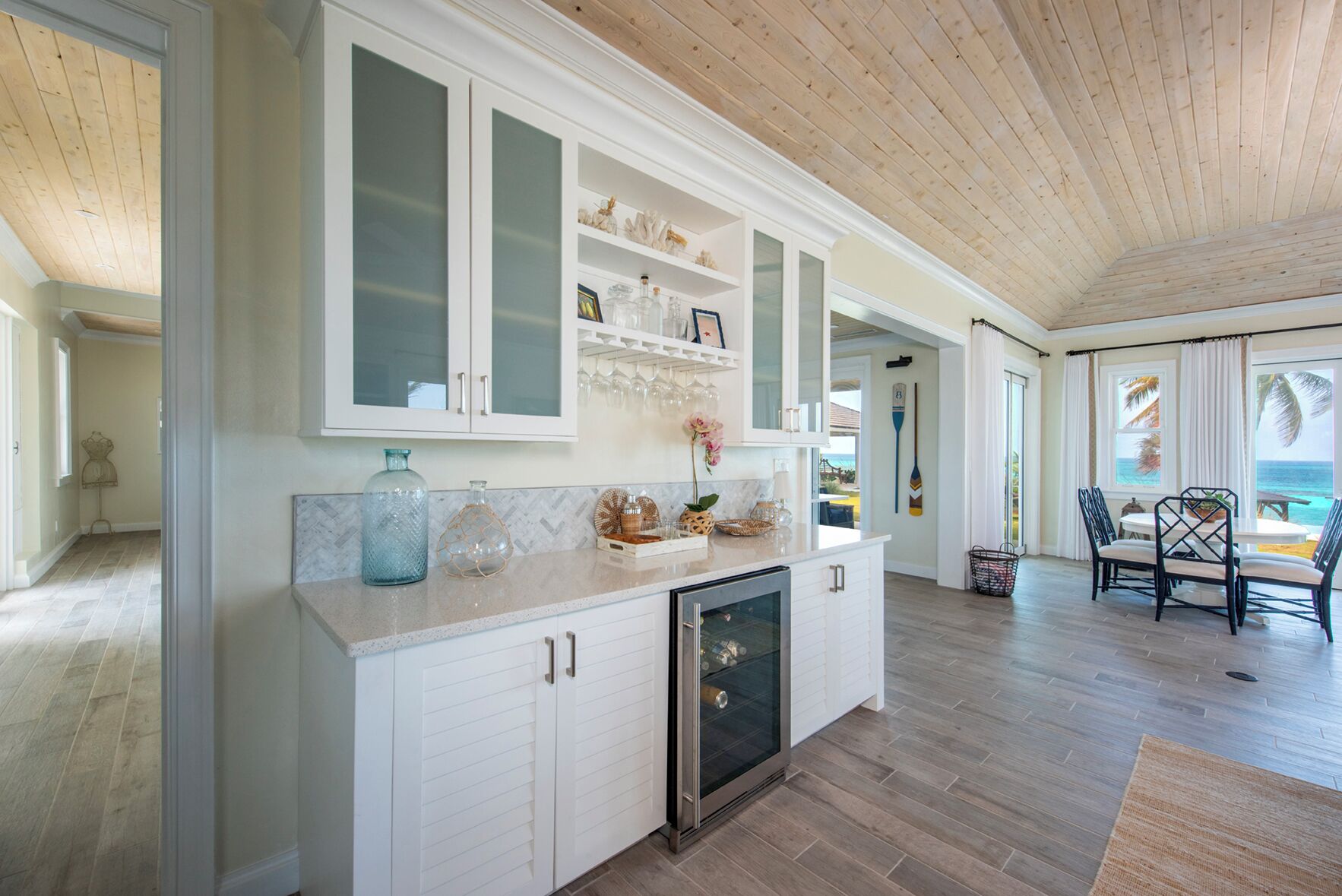 A kitchen with white cabinets, a built-in oven, and a countertop with decorative items.
