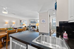 Een moderne keuken met een roestvrijstalen spoelbak, een houten eettafel en stoelen.