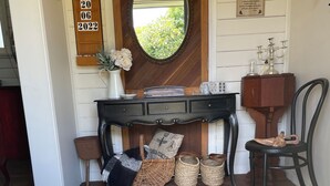 A well-decorated entryway with a welcome mat, a mirror, a wooden sign with a date, and a wicker basket.