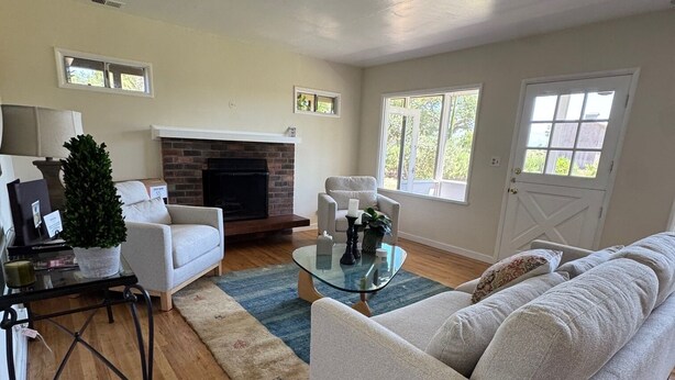 A living room with a fireplace, a sofa, a coffee table, and a TV.