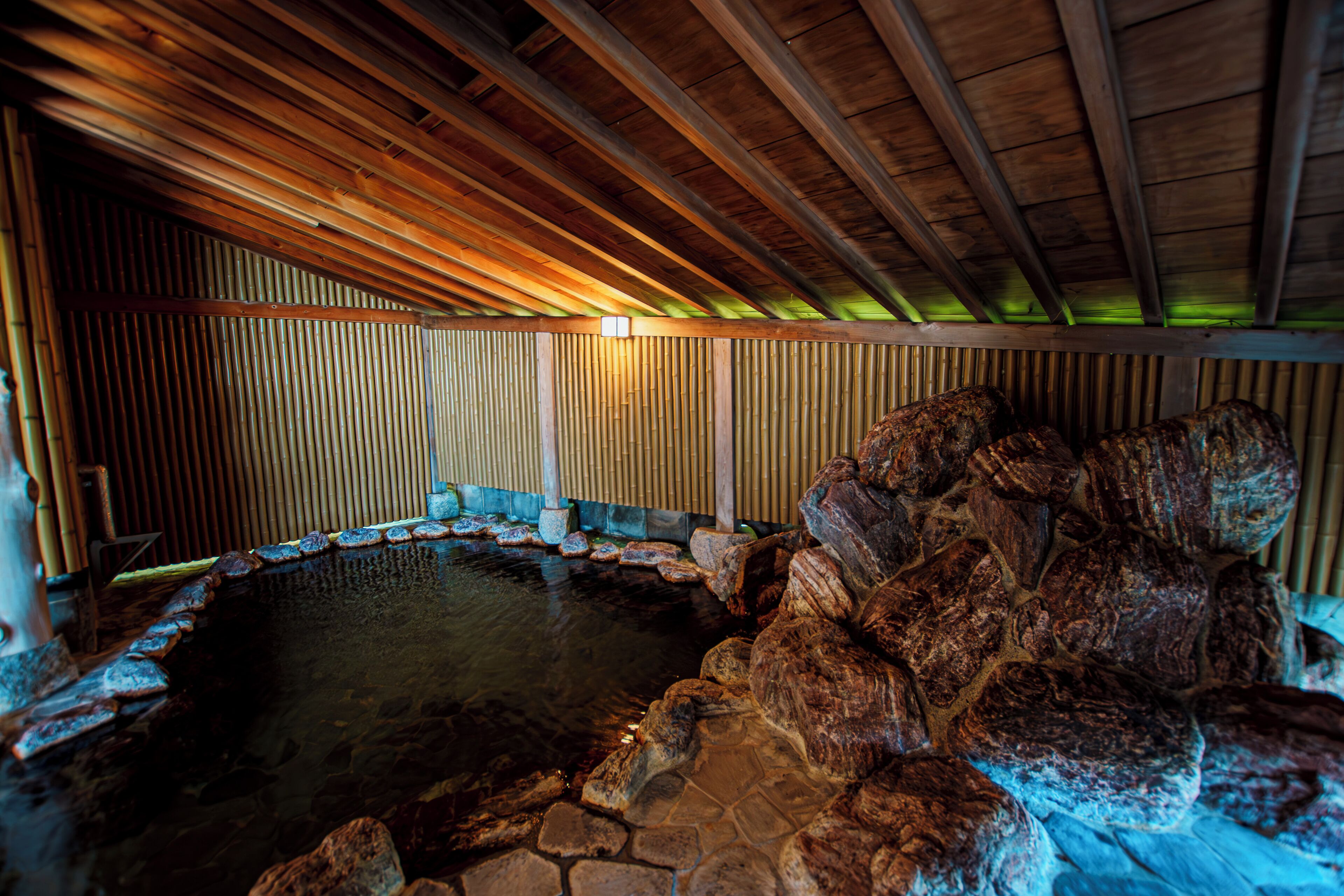 A hot spring area with wooden beams and stone walls.