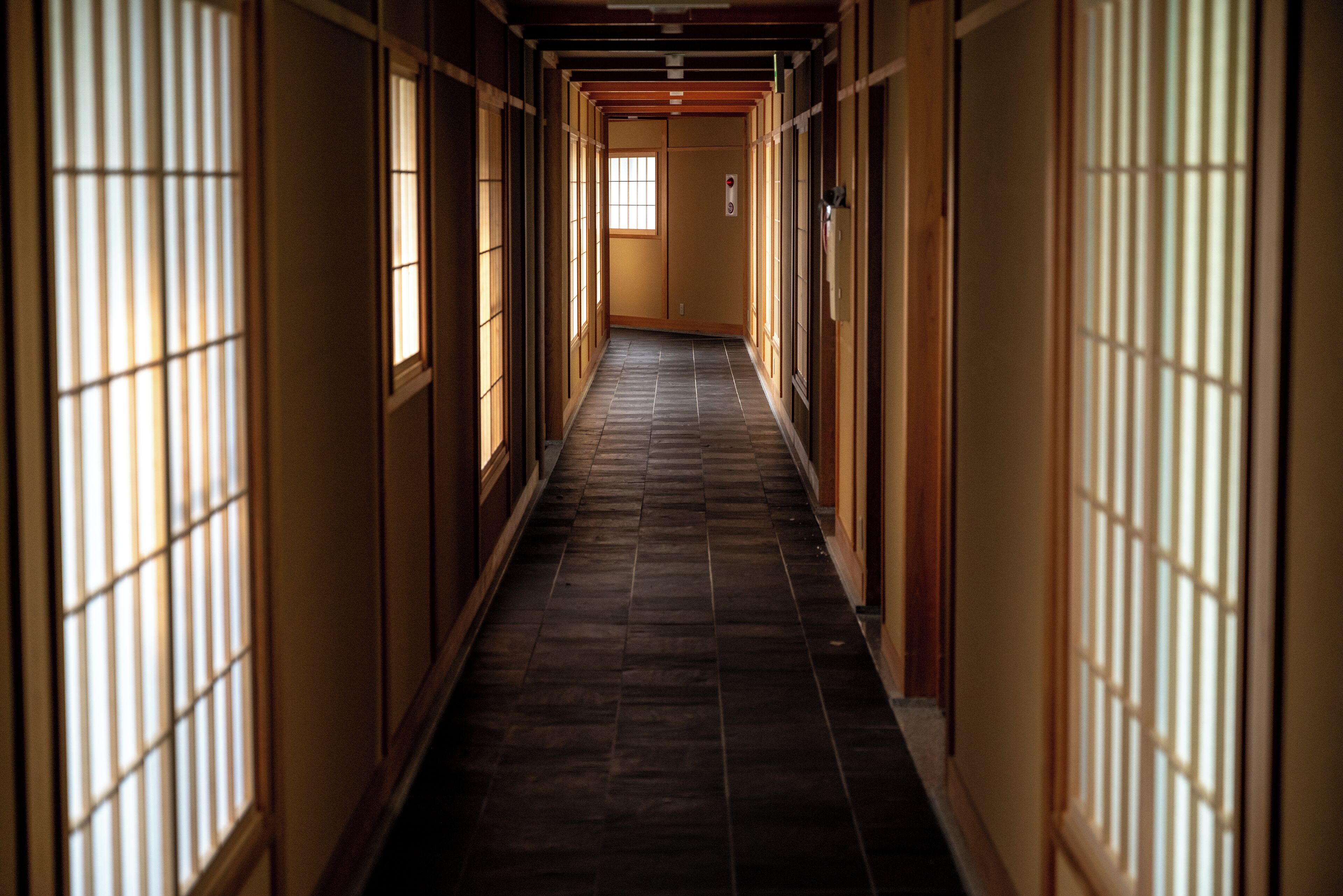 A corridor with traditional sliding doors and a tiled floor.