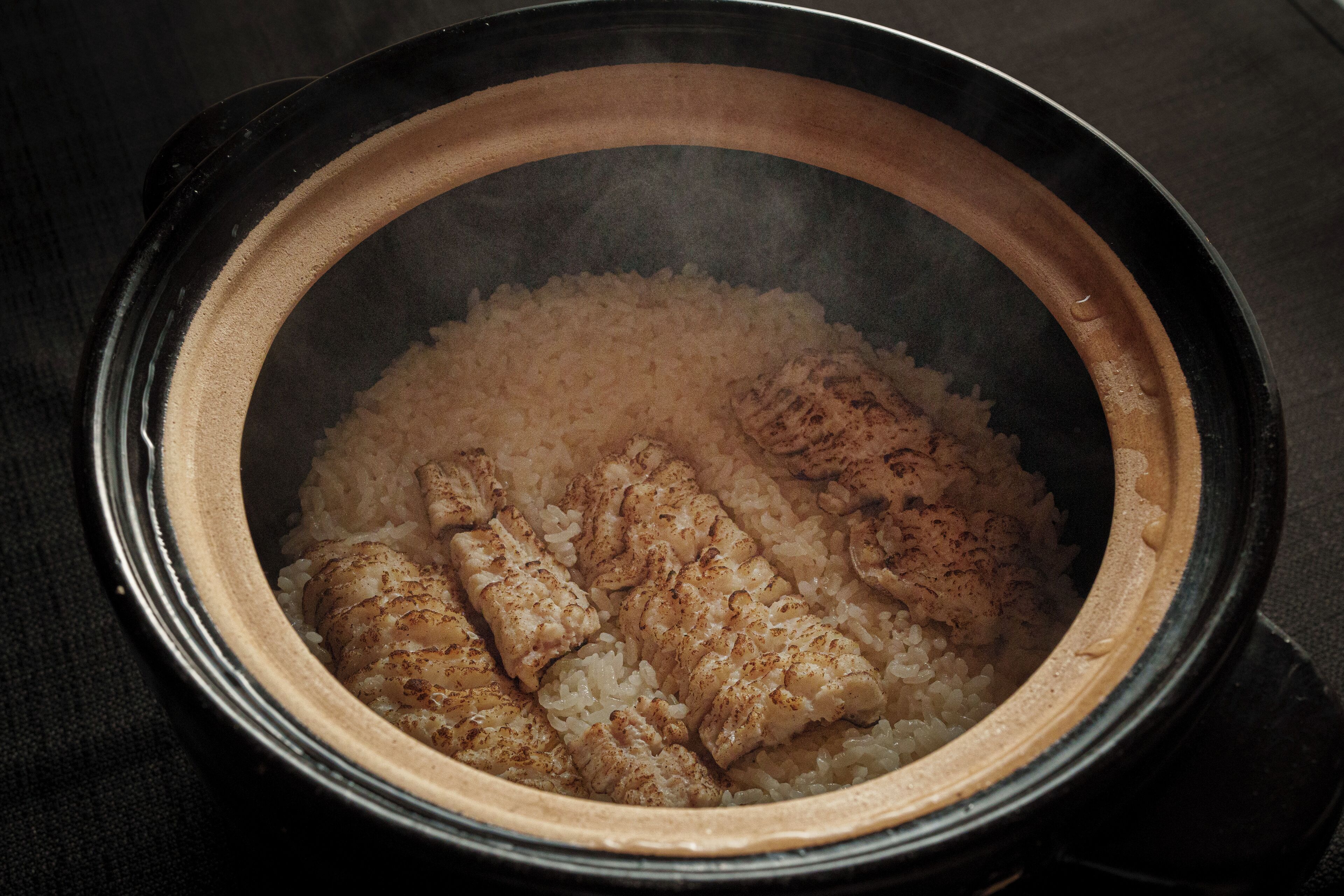 A slow cooker with rice and chicken pieces inside.