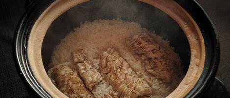 A slow cooker with rice and chicken pieces inside.