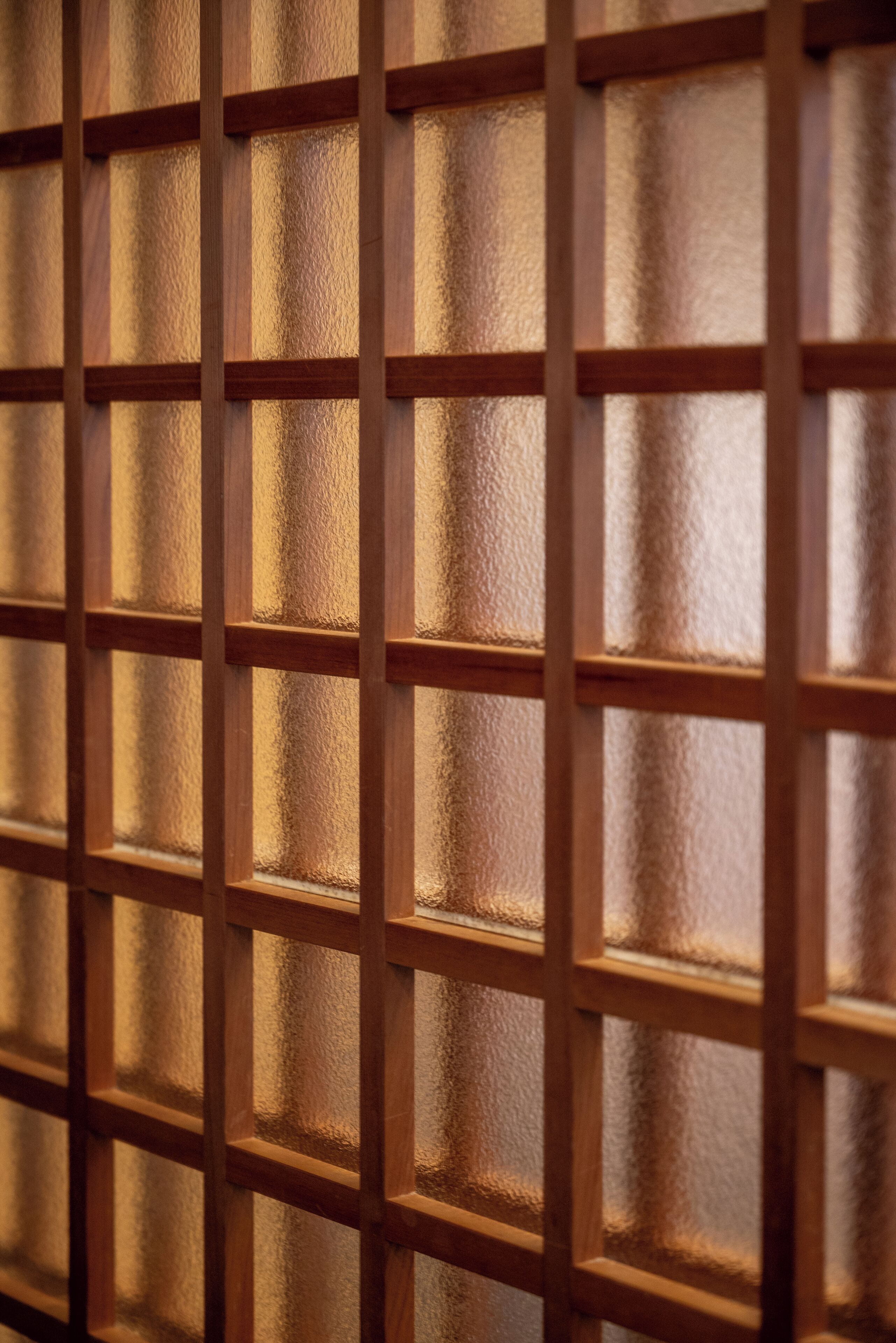 A close-up of a wooden grid structure, likely part of a room's interior design.