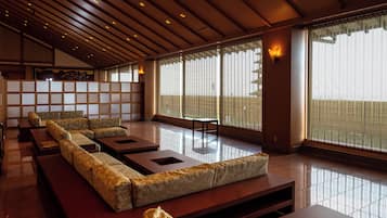 A traditional Japanese-style room with tatami mats, low wooden tables, and a sliding shoji screen.