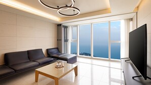 A modern living room with a sofa, a coffee table, and a TV. - LCT residence THE VINE Haeundae (Busan)
