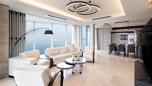 A modern living room with a sofa, coffee table, and dining area. - LCT residence THE VINE Haeundae (Busan)