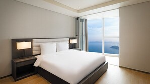 A modern hotel room with a large bed, two bedside tables with lamps, a view of the sea, and a skylight. - LCT residence THE VINE Haeundae (Busan)