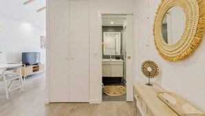 Ein modernes Interieur mit Essbereich, Fernseher, Kleiderschrank, Badezimmer und Wanddekoration.
