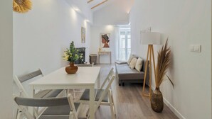 Ein modernes Wohnzimmer mit einer Couch, einem Esstisch und einem Gemälde an der Wand.