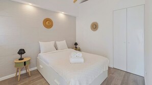 Ein Schlafzimmer mit einem Bett, Nachttischen und einem Kleiderschrank.