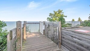 Eine Holzterrasse führt zu einem Strand mit freiem Blick auf das Meer.