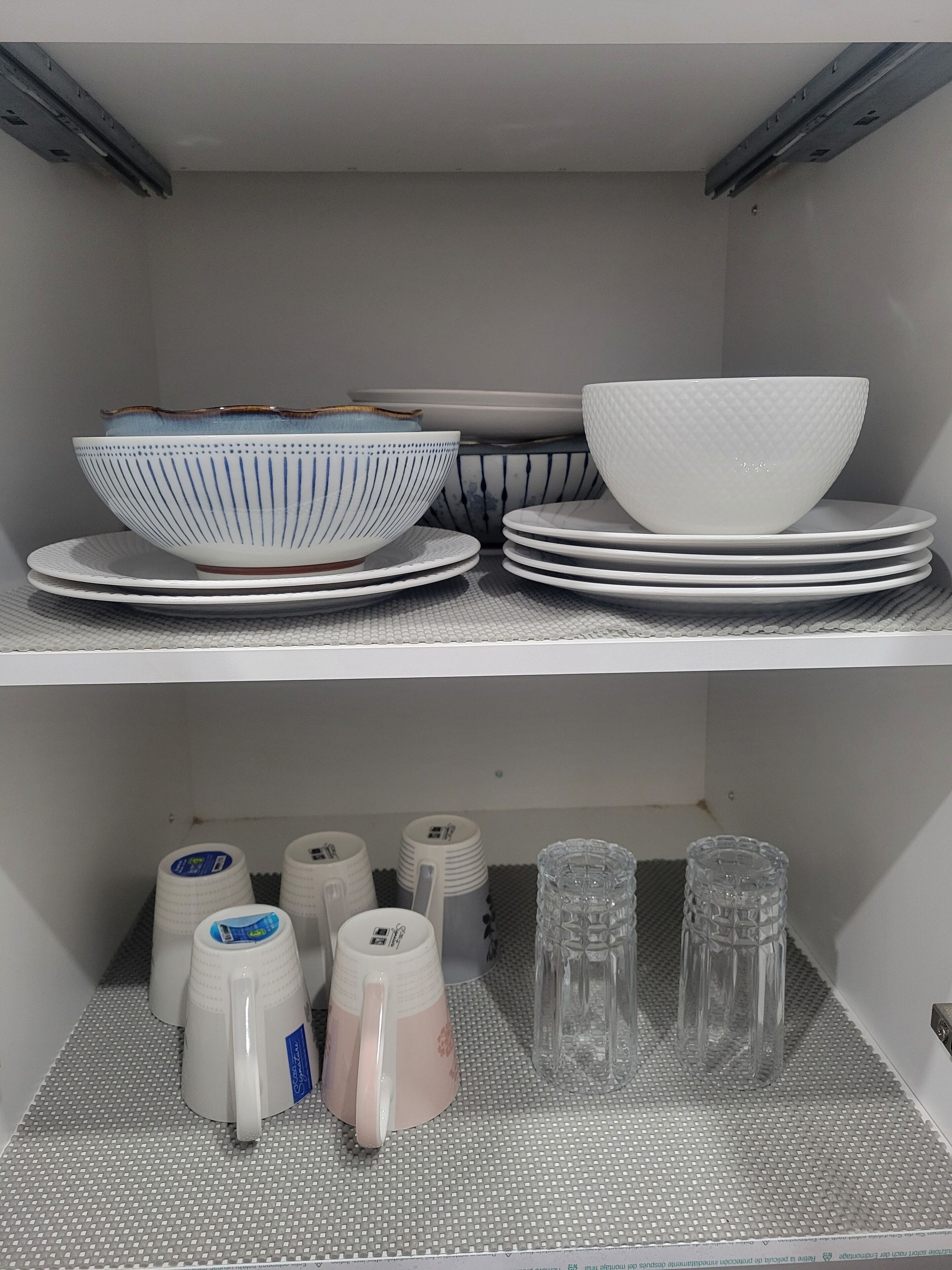 Un espace de rangement doté d’étagères où sont rangés des bols, des assiettes et des tasses.