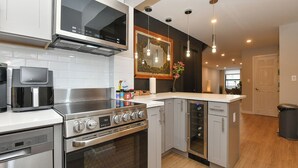 A modern kitchen with stainless steel appliances, a built-in oven, and a wine cooler. - Elegant SoHo 5BR Duplex – Upscale, Central & Spacious (New York)