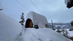 A snow-covered landscape with a wooden structure partially buried in snow. - Mountain Bliss, view and Sauna - Swiss Alps (Anzère)