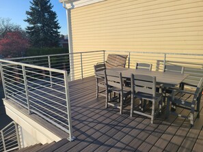 Enjoy the serene views of the surrounding neighborhood from this balcony with a table and four chairs.