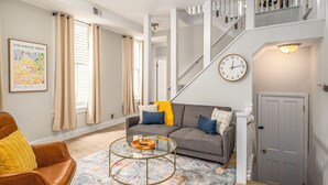 A living room with a sofa, coffee table, and a staircase. - Prime Mt Adams+Lux Beds+Sleeps 6ppl+Deck Views+Smart TVs+Spacious Living Rooms (Cincinnati)