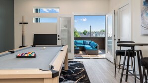 A modern room with a pool table, a sofa, and a bar area. - 3-bedroom house in welcoming Houston with WiFi, AC, EV Charging (Houston)