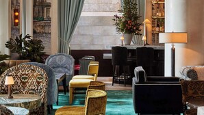 Un hall amplio con un gran ventanal, un mobiliario elegante y una zona de bar.