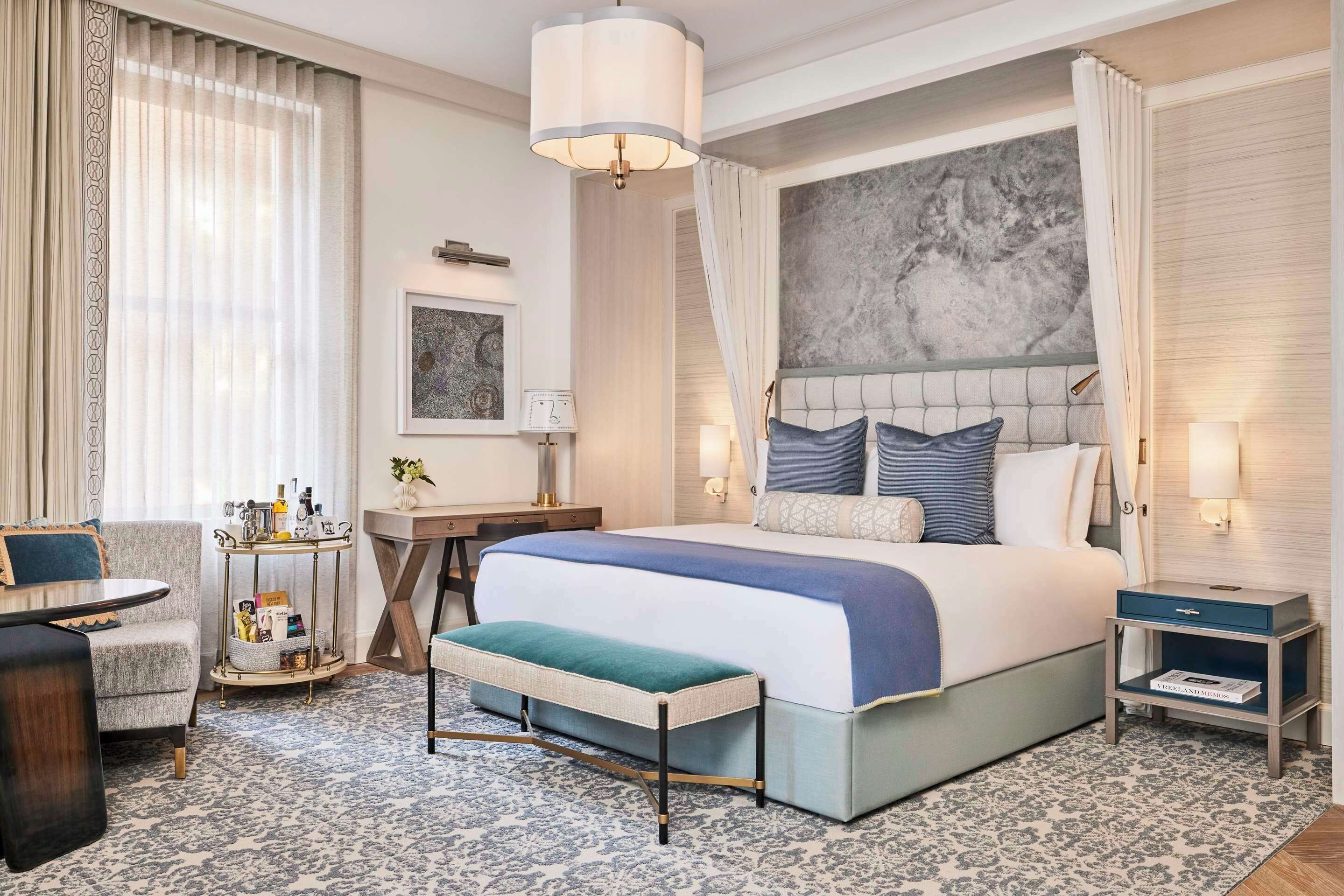 Een hotelkamer met een groot bed, nachtkastjes, een bureau en een stoel.