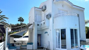 A modern two-story house with a swimming pool, outdoor seating, and a covered patio area. - STAY ALKYONI Villa (Protaras)