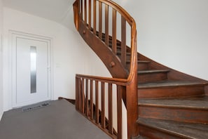A wooden staircase with a handrail leading to a white door. - Apartment 'Mirjam' (Lohr am Main)