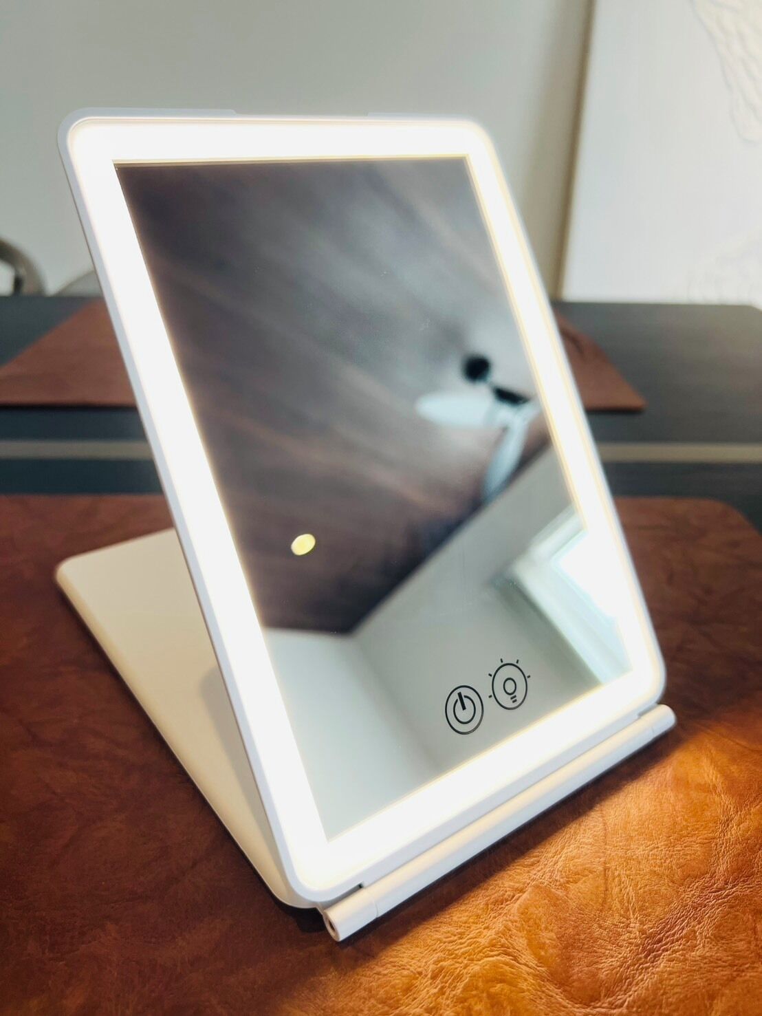 A tablet on a stand with a reflective surface.