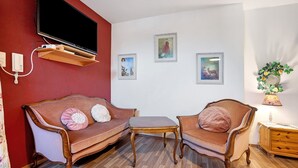 A living room with a TV, two sofas, a coffee table, and framed pictures on the wall. - 'Fantasy' Holiday Apartment with Wi-Fi (Lindau)
