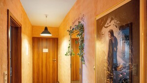 A hallway with wooden doors, a hanging pendant light, and a poster of a woman with the text 'Snow White and the Seven Dwarfs'. - 'Fantasy' Holiday Apartment with Wi-Fi (Lindau)