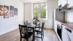 Una cocina moderna con una mesa de comedor, sillas, un ventanal y electrodomésticos integrados.