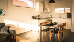 Una cocina moderna con comedor, sofá y vistas al exterior.