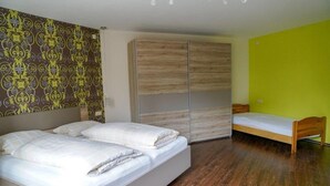 A bedroom with a bed, a wardrobe, and a small table. - Apartment 'Roth' with Terrace and Wi-Fi (Frickingen)