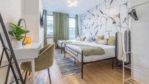 Une chambre à coucher moderne avec un lit, un bureau, une chaise et une plante en pot.