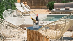 A poolside area with lounge chairs, a table with a bottle of champagne, and glasses. - Can Cama Rotja, pool, barbecue & incredible views (Inca)