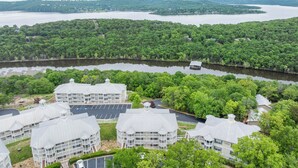 Et hotel ved søen med flere bygninger, en bro og en parkeringsplads.