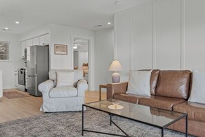 A modern living room with a sofa, armchair, and coffee table. - Gated Lake View Condo W/ pool, private boat ramp, putt putt, views of lake (Kimberling City)