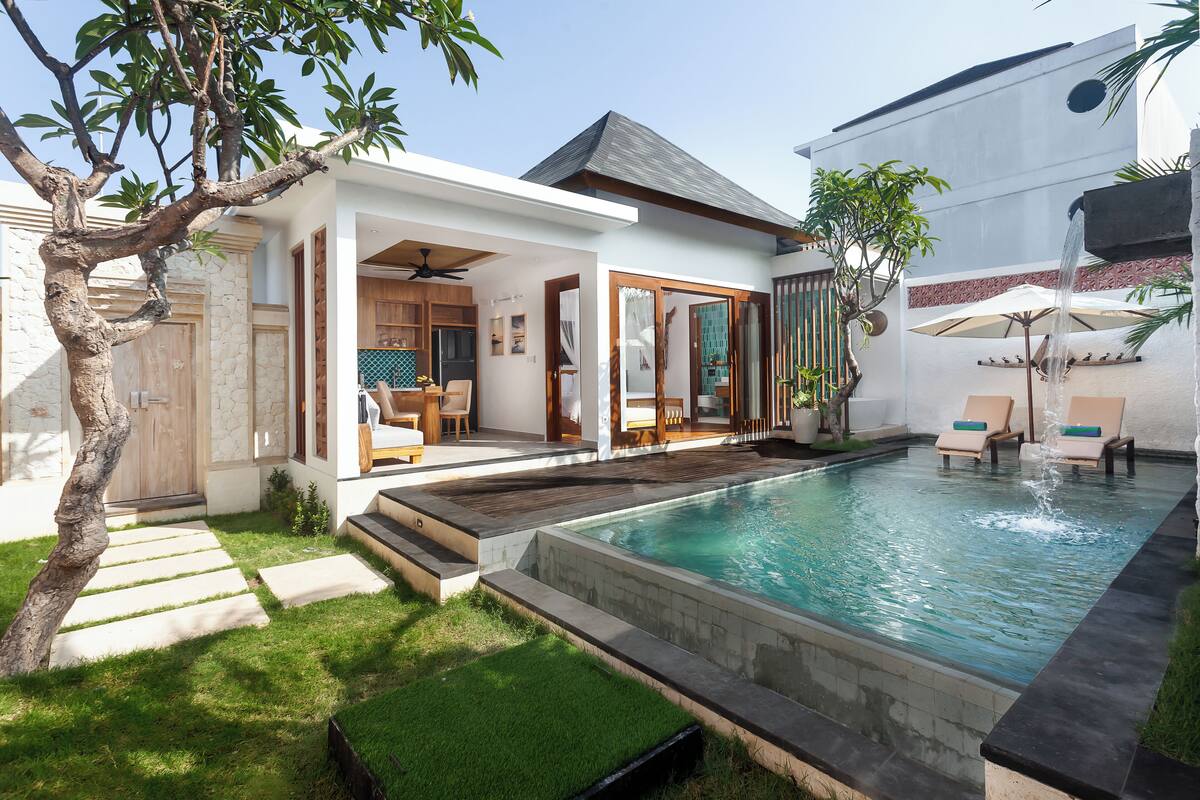 Une maison moderne dotée d’une piscine, d’une terrasse avec des chaises longues et d’une plateforme en bois.