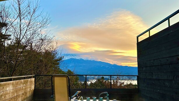 A hot tub with a view of a mountain range and a sunset. - Retreat Camp Mahoroba (Fujikawaguchiko)