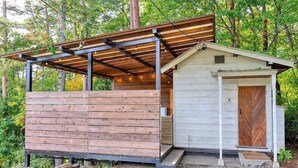 A small wooden cabin with a sloped roof and a porch area. - Retreat Camp Mahoroba (Fujikawaguchiko)