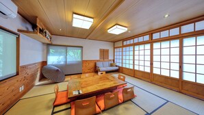 A traditional Japanese room with tatami flooring, a wooden table, and a view through shoji screens. - Retreat Camp Mahoroba (Fujikawaguchiko)