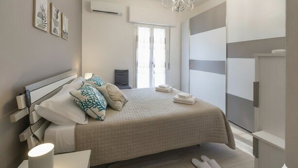 A modern bedroom with a bed, bedside table, and a nightstand. - Comfort and Relax in the Heart of Imperia | Ap44 (Imperia)