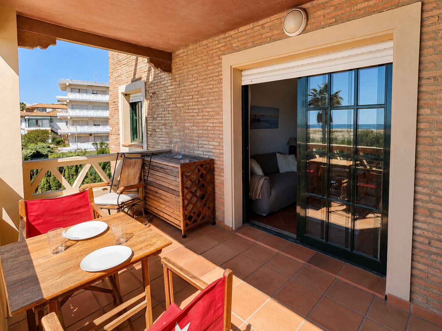 Ein Balkon mit Holztisch, Stühlen und einer Couch.
