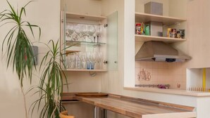 Une cuisine moderne dotée d’un bar intégré, d’une plante en pot et d’un tabouret.